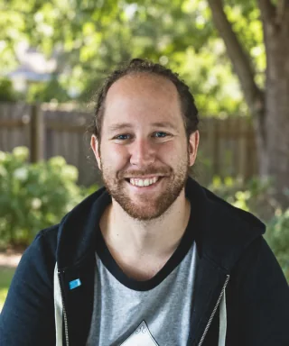 Sample portrait of a smiling man outdoors with trees in the background